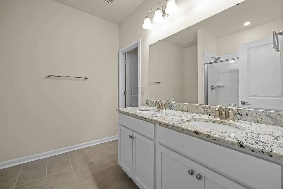 Finished bathroom vanity with stone counter, mirror, towel bar, and tile floor