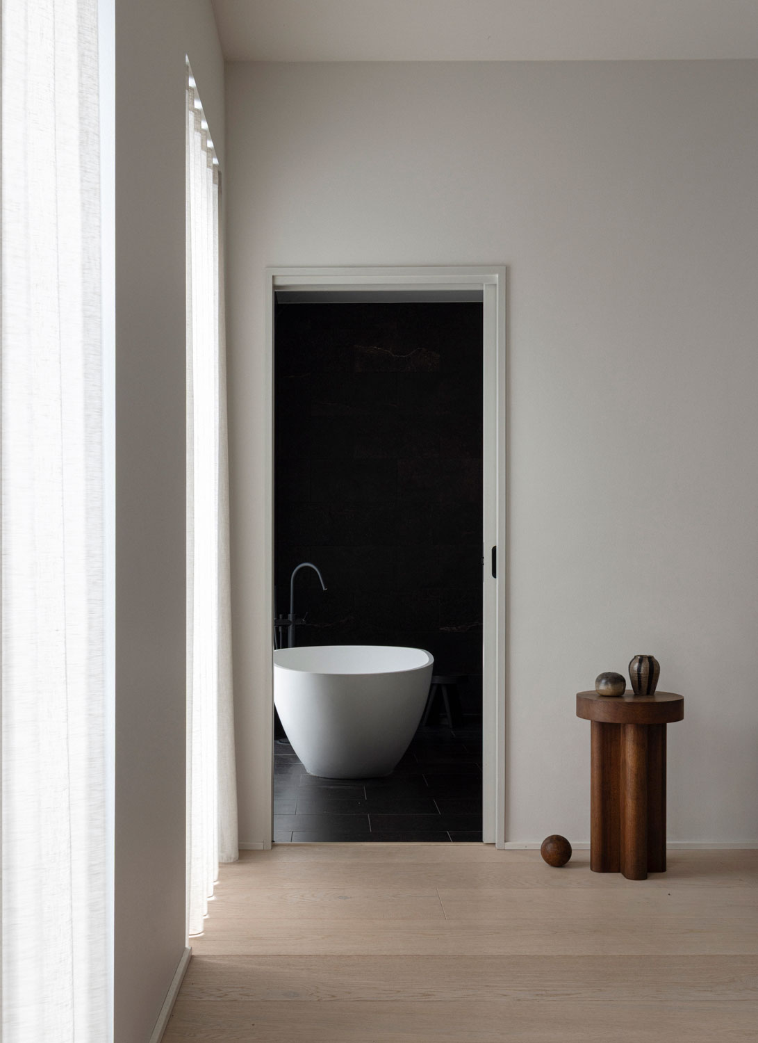 Light bathroom with freestanding tub, large tile, and calm finish palette