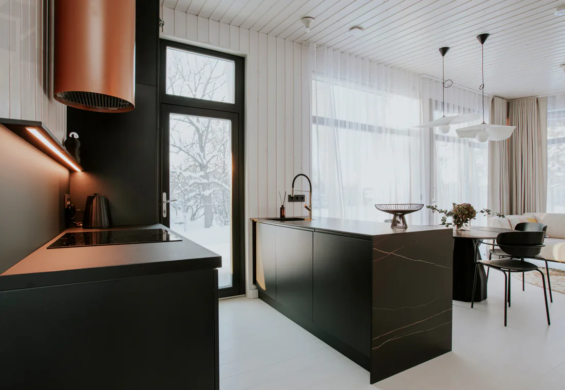 Kitchen with dark cabinetry, copper range hood, and bright ceiling detail