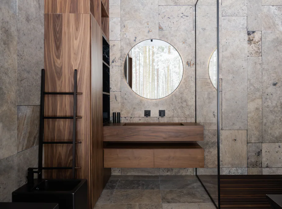 Dark spa-style bathroom with stone, wood, and black fixtures